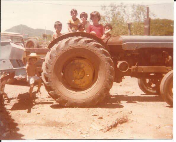 Familia Castro sobre maquinaria agrícola, fotografía de archivo